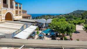 A coastal hotel with a restaurant on the ground floor, outdoor seating, and a view of the sea and hills. - Le Village (B1 331) by Interhome (Agay Village Cap Esterel)