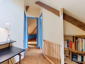A room with a desk, a bookshelf, and a staircase leading to an upper level. - Vacation home Ty Coz by Interhome (Pleurtuit)