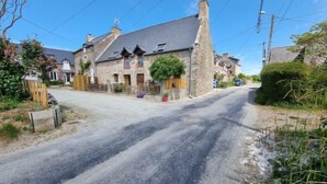 A rural road with stone houses, a wooden fence, and a clear sky. - Vacation home Ty Coz by Interhome (Pleurtuit)
