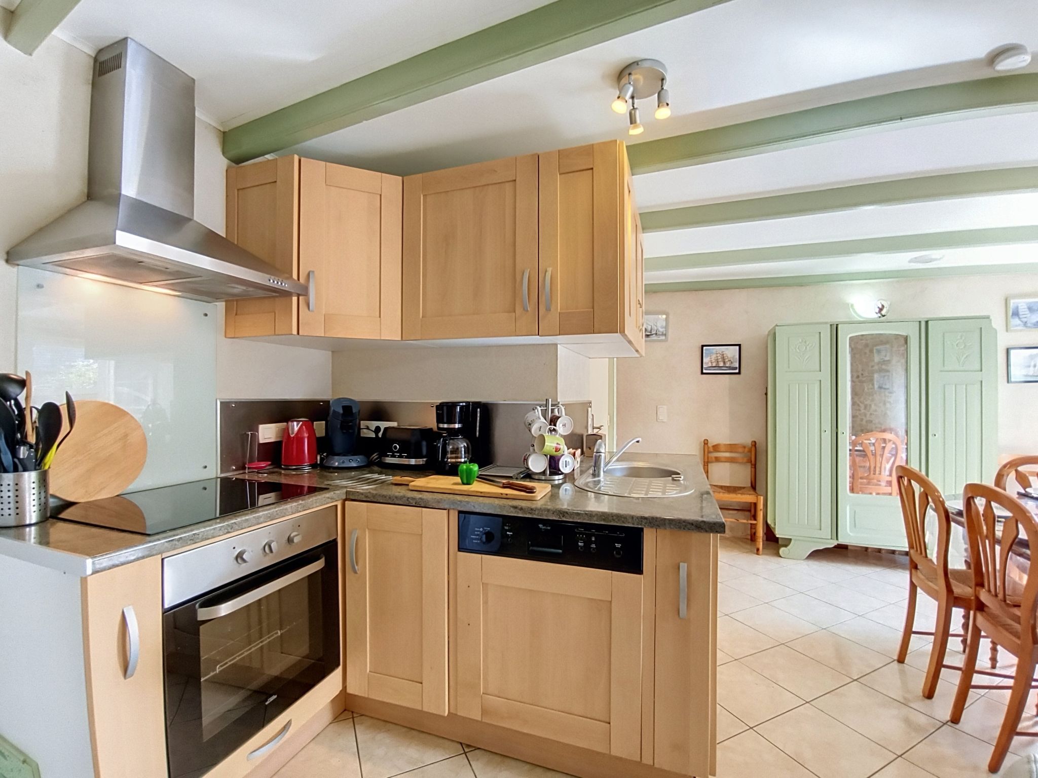A compact kitchen with wooden cabinets, a built-in oven, and a dishwasher.