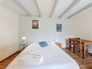 A bedroom with a bed, a desk, and two wall-mounted pictures. - Vacation home Ty Coz by Interhome (Pleurtuit)