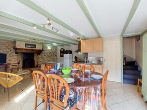 A dining area with a table set for four, surrounded by wooden chairs. - Vacation home Ty Coz by Interhome (Pleurtuit)