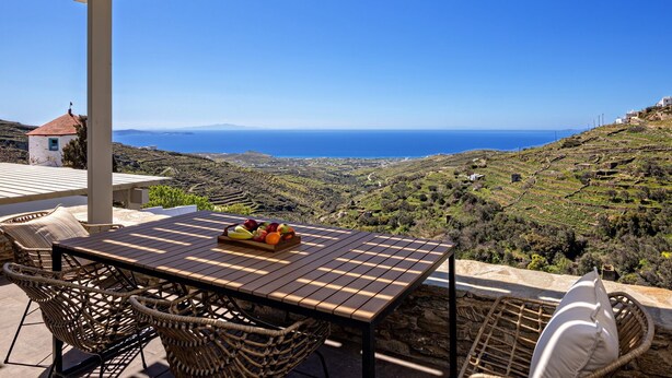 A terrace with a table, wicker chairs, and a fruit bowl. - Villa Erato in Triantaros Tinos (Tinos island)