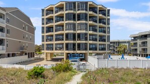 A multi-story residential building with balconies and large windows. - Large, oceanfront family condos in quiet, secluded area-balcony, pool (North Myrtle Beach)