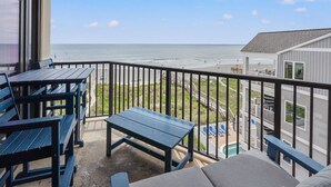 A balcony with a view of the beach, outdoor seating, and a pool area. - Large, oceanfront family condos in quiet, secluded area-balcony, pool (North Myrtle Beach)