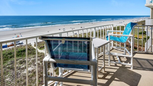 Ein Balkon mit Blick auf Strand und Meer.