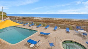 A pool area with lounge chairs, a small pool, and a view of the beach. - Seaside Resort- modern beach destination! (North Myrtle Beach)