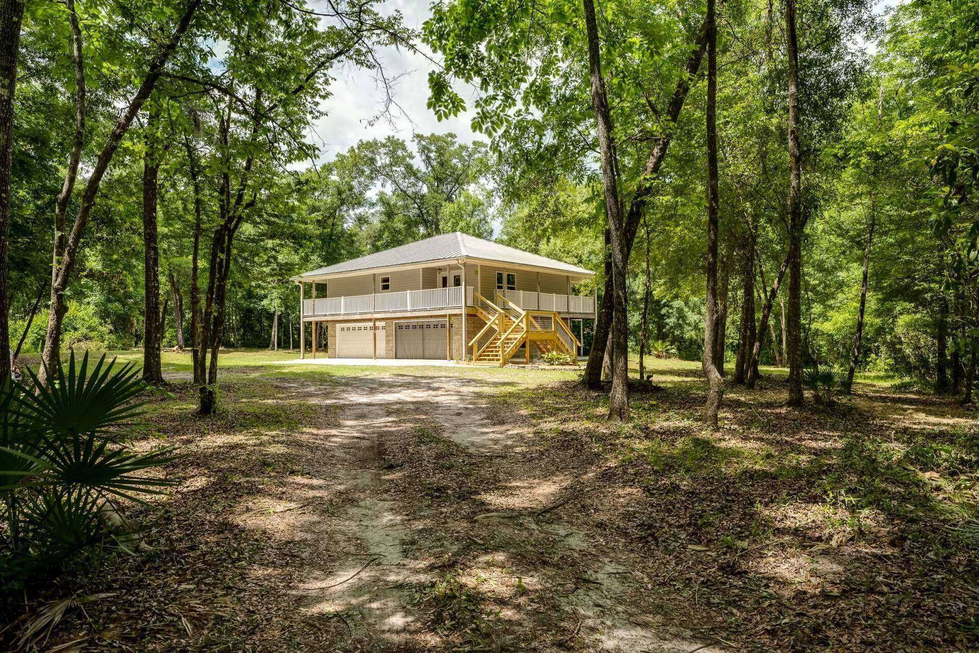 Exterior Retreat: Embrace nature from your spacious wraparound porch among the trees!