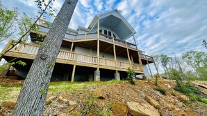 A multi-story house with a balcony, surrounded by trees and a clear sky. - New! Private 5BR 5,000 SqFt Lake House on 7 Acres (Dandridge)