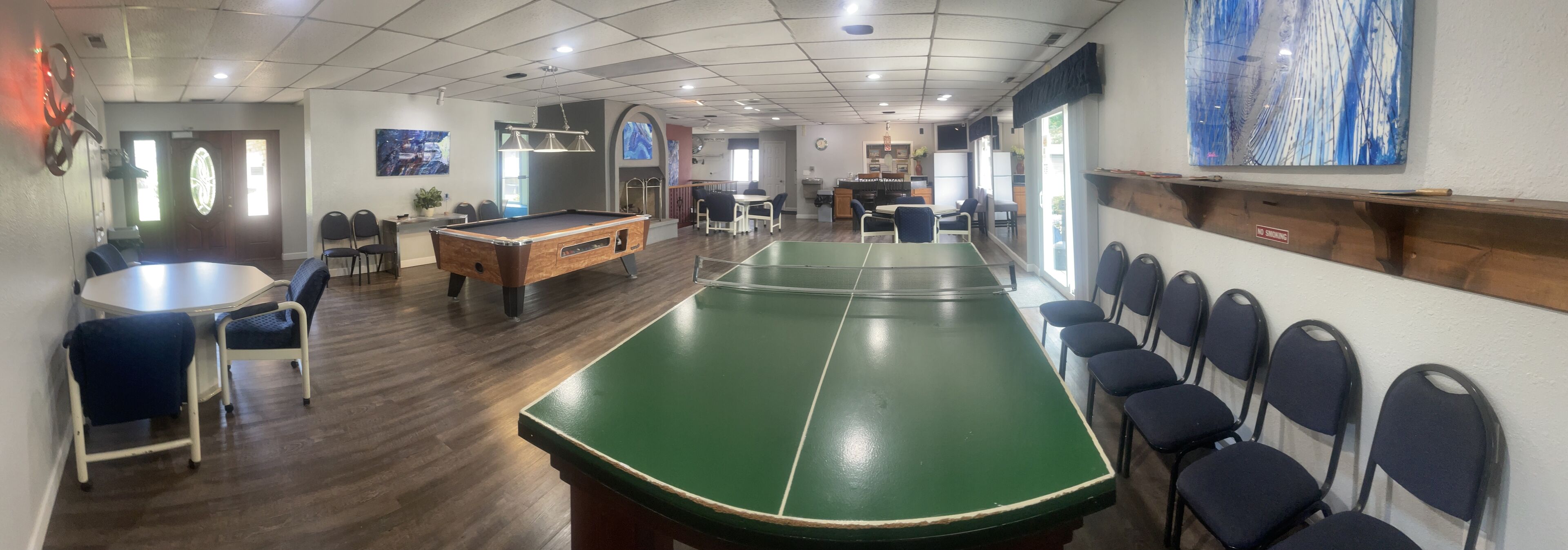 Una sala giochi con tavolo da biliardo, tavolo da ping pong e diversi posti a sedere.