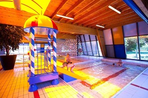 Swimmers can enjoy the pool area with a checkered tile floor and a fun play structure.
