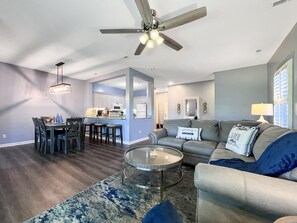 Relax in this stylish living space featuring a comfortable sofa, dining area, and fully equipped kitchen.