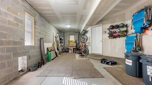 A narrow hallway with a brick wall, a door at the end, and a bike rack on the right. - Gorgeous 4 Br Townhouse Only Steps Away from Beach (North Wildwood)