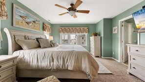 A bedroom with a bed, a ceiling fan, a window, a dresser, and a painting on the wall. - Gorgeous 4 Br Townhouse Only Steps Away from Beach (North Wildwood)
