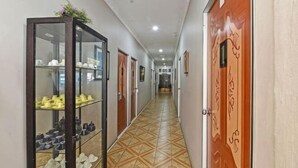 Un pasillo con un expositor de zapatos, puertas de madera y un suelo estampado.