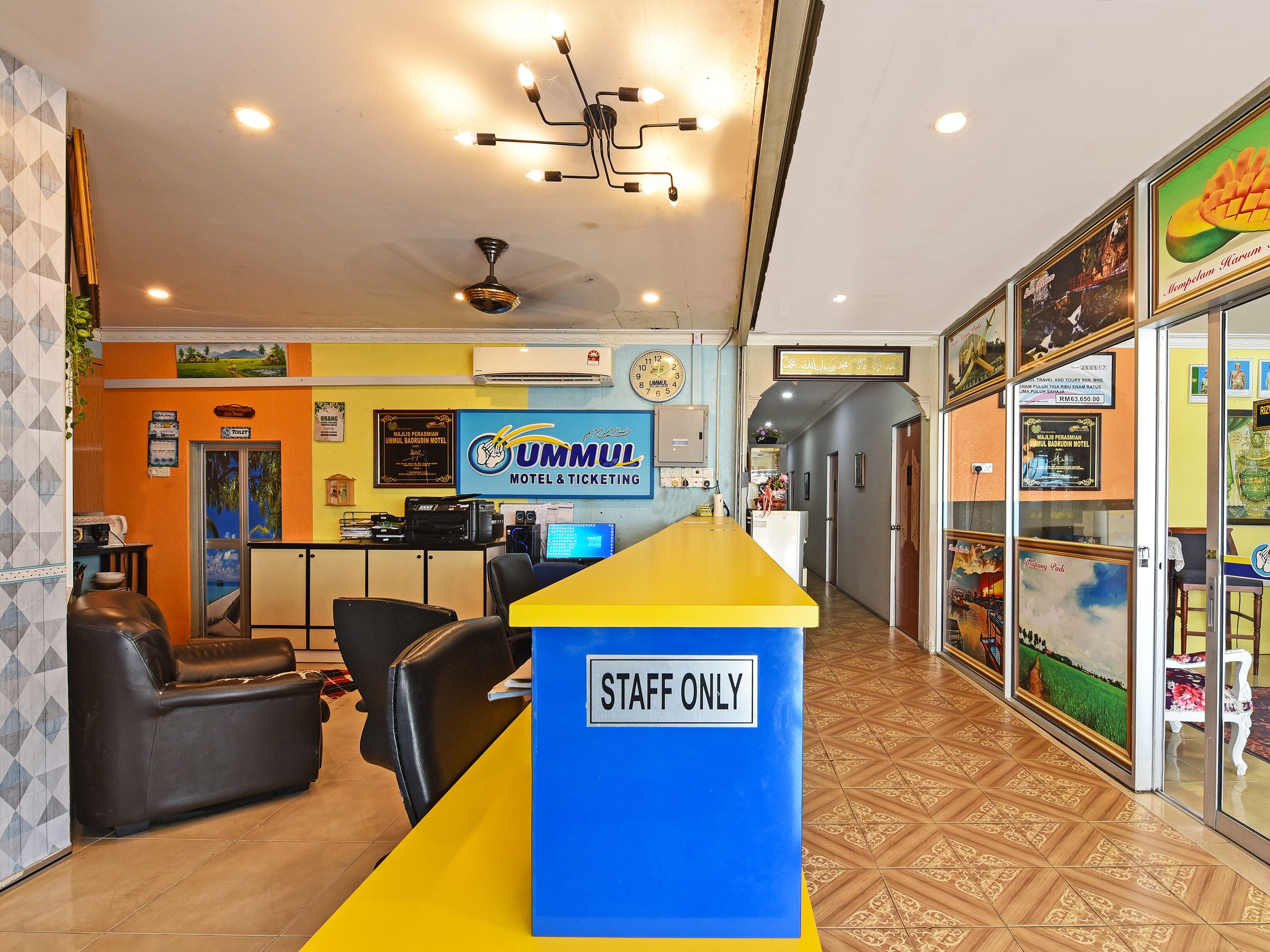 A reception area with a 'STAFF ONLY' sign, a counter, seating, and a ceiling fan.