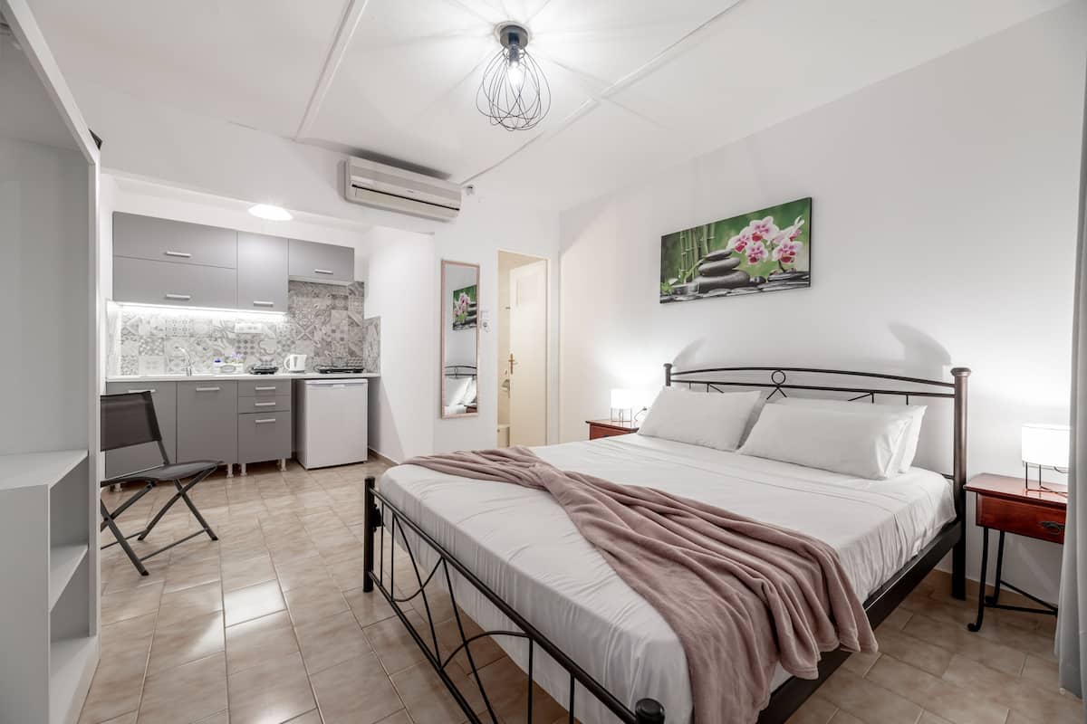 A modern bedroom with a bed, bedside table, and a painting on the wall.