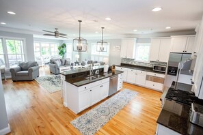 A modern kitchen with white cabinetry, a central island, and stainless steel appliances.