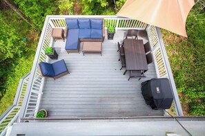 A deck with outdoor furniture including a sofa, chairs, and a table.