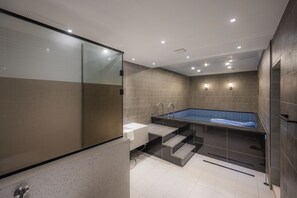 A modern bathroom with a glass-enclosed shower, a built-in sink, and a separate bathtub area. - Brown Dot Hotel Gijang Station (Busan)