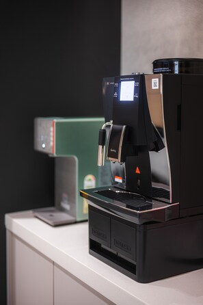 A coffee machine on a counter with a digital display and a QR code. - Brown Dot Hotel Gijang Station (Busan)