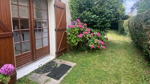 A house with a garden, wooden shutters, and a small entrance with a mat. - House with garden 800m from the 2 beaches of Saint Cast (Saint-Cast-le-Guildo)