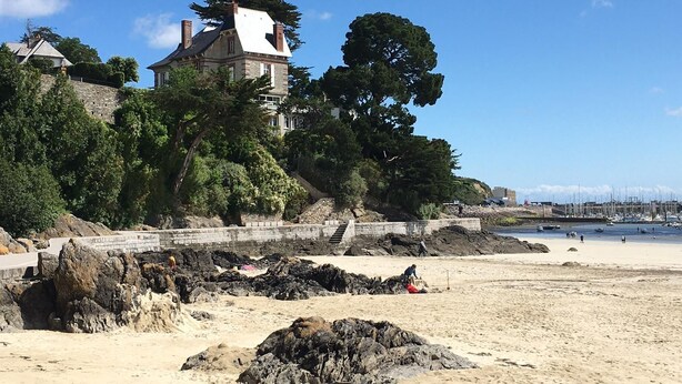 A coastal building with a stone facade, surrounded by trees and a sandy beach. - House with garden 800m from the 2 beaches of Saint Cast (Saint-Cast-le-Guildo)