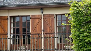 A two-story building with a balcony and wooden shutters on the windows. - House with garden 800m from the 2 beaches of Saint Cast (Saint-Cast-le-Guildo)