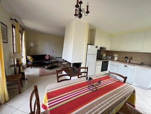 A compact living space with a dining area, kitchen, and a sofa in the living room.