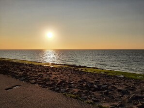 Eine felsige Küste bei Sonnenuntergang über dem Meer.
