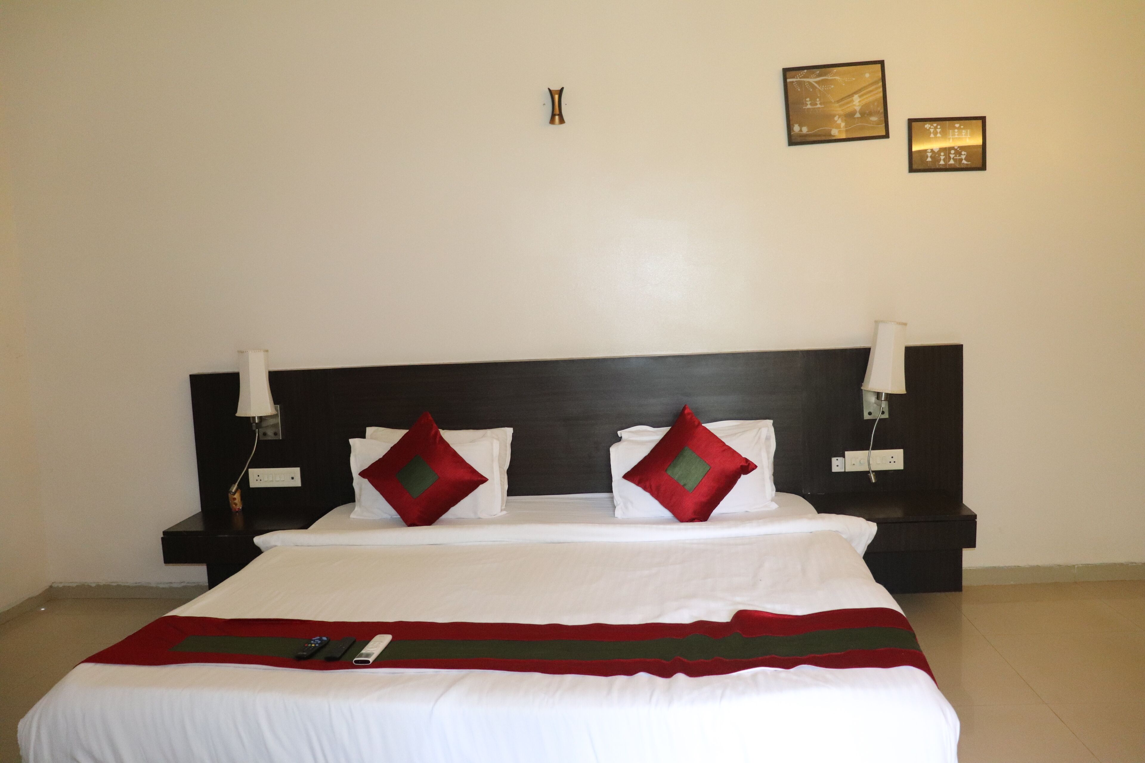 A hotel room with a large bed, two bedside tables, and a headboard.
