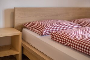 A bed with a wooden headboard and checkered bedding.