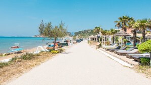 A beach path with lounge chairs and umbrellas, boats, and a clear view of the sea. - 'Mirage Arillas Studio Type A9' next to Beach with Balcony, Shared Pool & Wi-Fi (corfu)