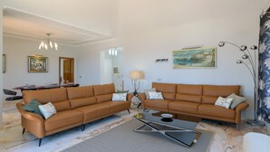 A living room with two brown sofas, a coffee table, a lamp, and a painting on the wall. - Vacation Rental 'Villa Loretta' with Sea View, Heated Pool & Wi-Fi (Puerto del Carmen)