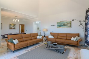 A living room with two brown sofas, a coffee table, a lamp, and a painting on the wall. - Vacation Rental 'Villa Loretta' with Sea View, Heated Pool & Wi-Fi (Puerto del Carmen)
