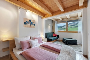 Un dormitorio con cama, mesita de noche y vistas al exterior.