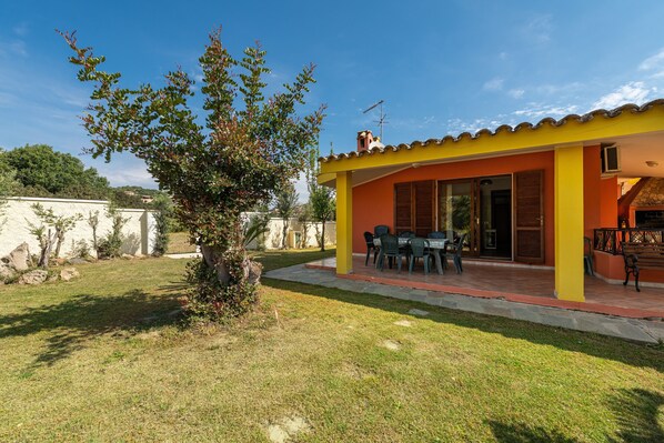 A house with a patio, a small tree, and a clear blue sky.