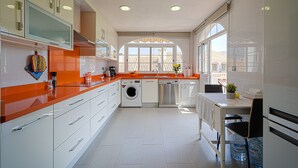 Eine moderne Küche mit Waschmaschine, Geschirrspüler und einem Essbereich mit Tisch und Stühlen.