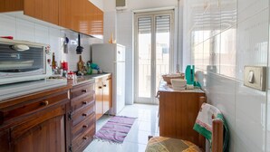 Eine Küche mit Holzausstattung, einer Mikrowelle und einem Kühlschrank.