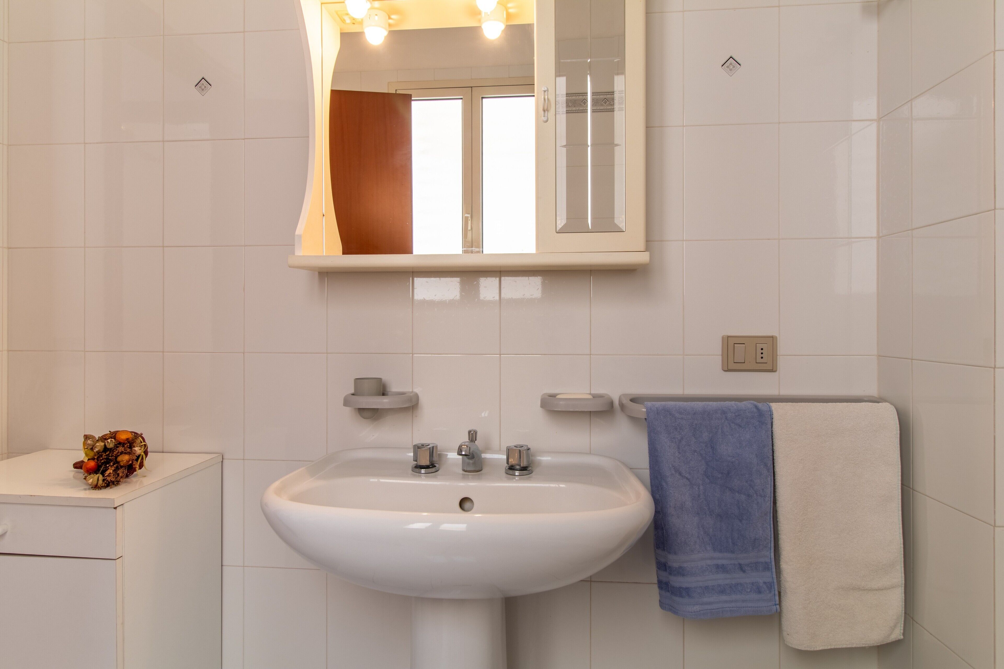 Ein Badezimmer mit Waschbecken, Spiegel und Handtuchhalter.
