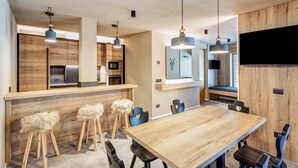 Een moderne keuken met houten kastjes, een centraal eiland en hangende lampen.