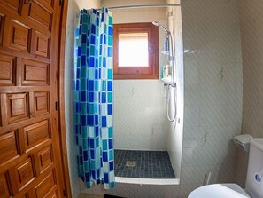 A bathroom with a shower, a toilet, and a wooden door. - Villa 'Anina' close to the Sea with Pool & Wi-Fi (Denia)
