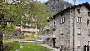 A stone building with multiple windows and balconies, a stone pathway, and a grassy area. - Apartment 'Bellavista' with Mountain View & Garden (Chiesa In Valmalenco)
