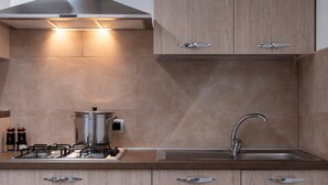 Eine moderne Küche mit Gasherd, Edelstahlspüle und Holzschränken.