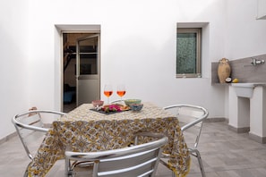 A dining area with a table set for two, a window, and a sink. - Holiday Home 'Francesca' close to City Centre with Garden & Air Conditioning (Menfi)