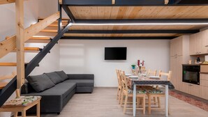 Eine moderne Küche mit Holzausstattung, einem Esstisch für vier Personen und einer Treppe mit Holzhandläufen.
