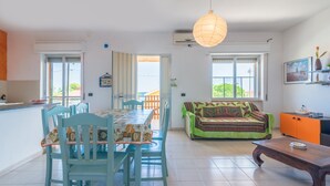 Un espace repas comprenant une table et des chaises, un canapé et une table basse en bois.