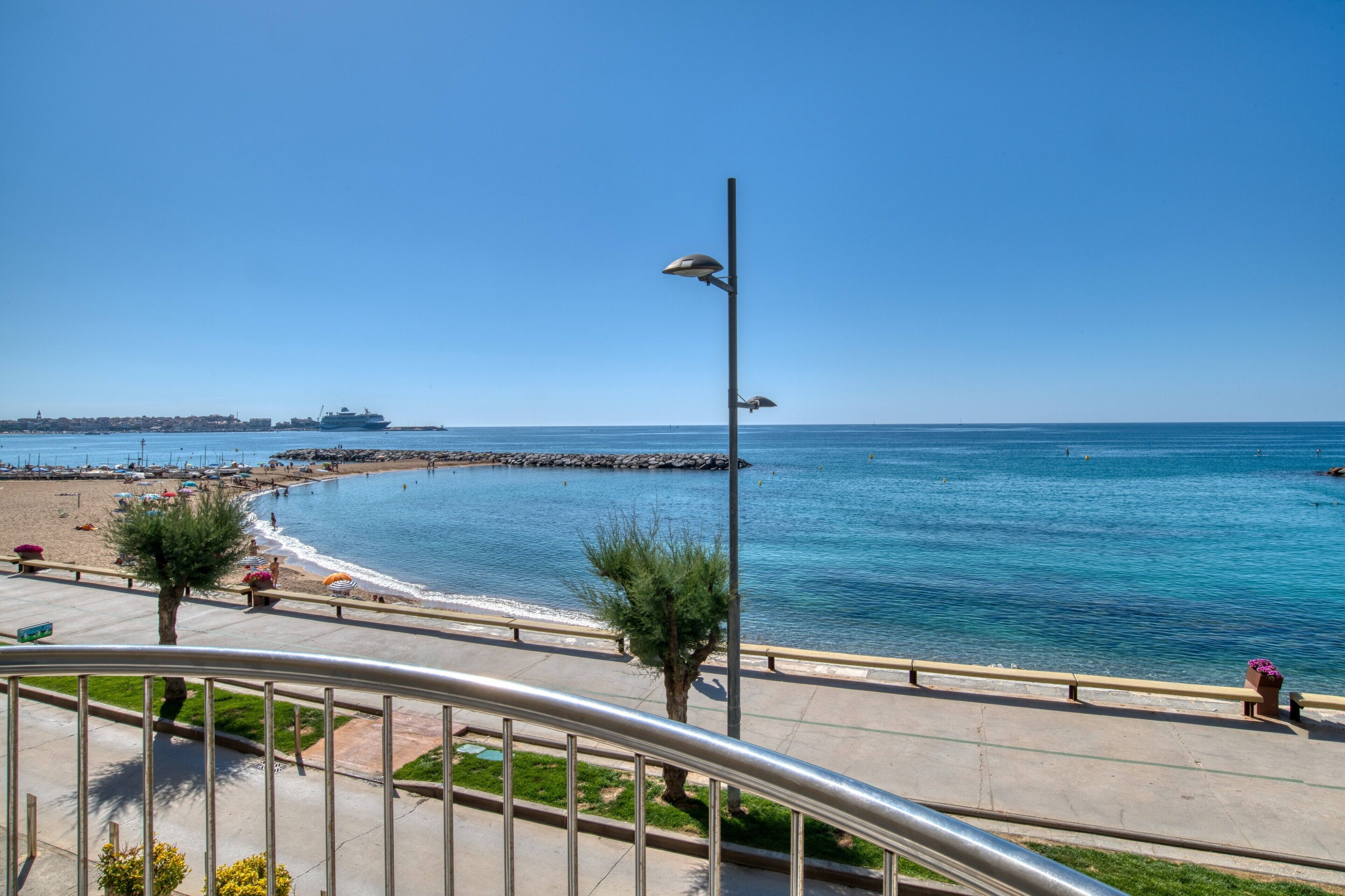 Eine Uferpromenade mit freiem Blick auf das Meer, einer Promenade-Umlauf und einem entfernten Schiff.