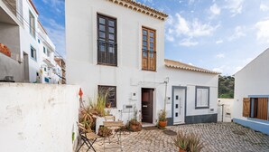 A white building with a tiled roof, a door, and a window. - Holiday Home "Casa da Praia 2" with Sea View, Terrace & Wi-Fi (Budens)