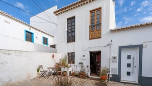 A white building with a tiled roof, a door, and windows. - Holiday Home "Casa da Praia 2" with Sea View, Terrace & Wi-Fi (Budens)